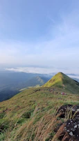 A family enjoying a scenic mountain hike in the hills of Bandarban under clear blue skies.