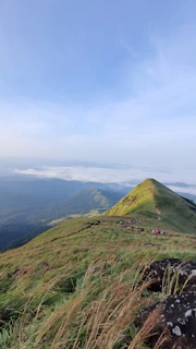 A family enjoying a scenic mountain hike in the hills of Bandarban under clear blue skies.
