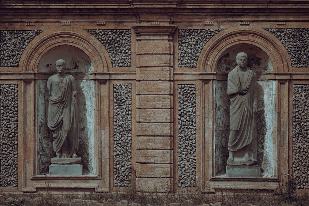 un paio di statue sul lato di un edificio