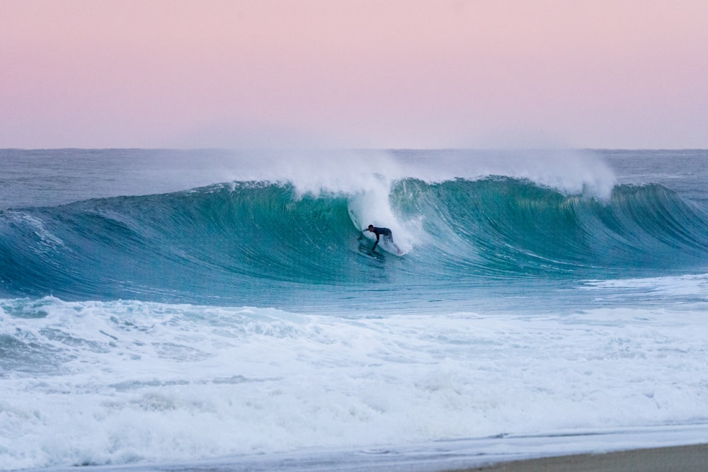 a man riding a wave on top of a surfboard