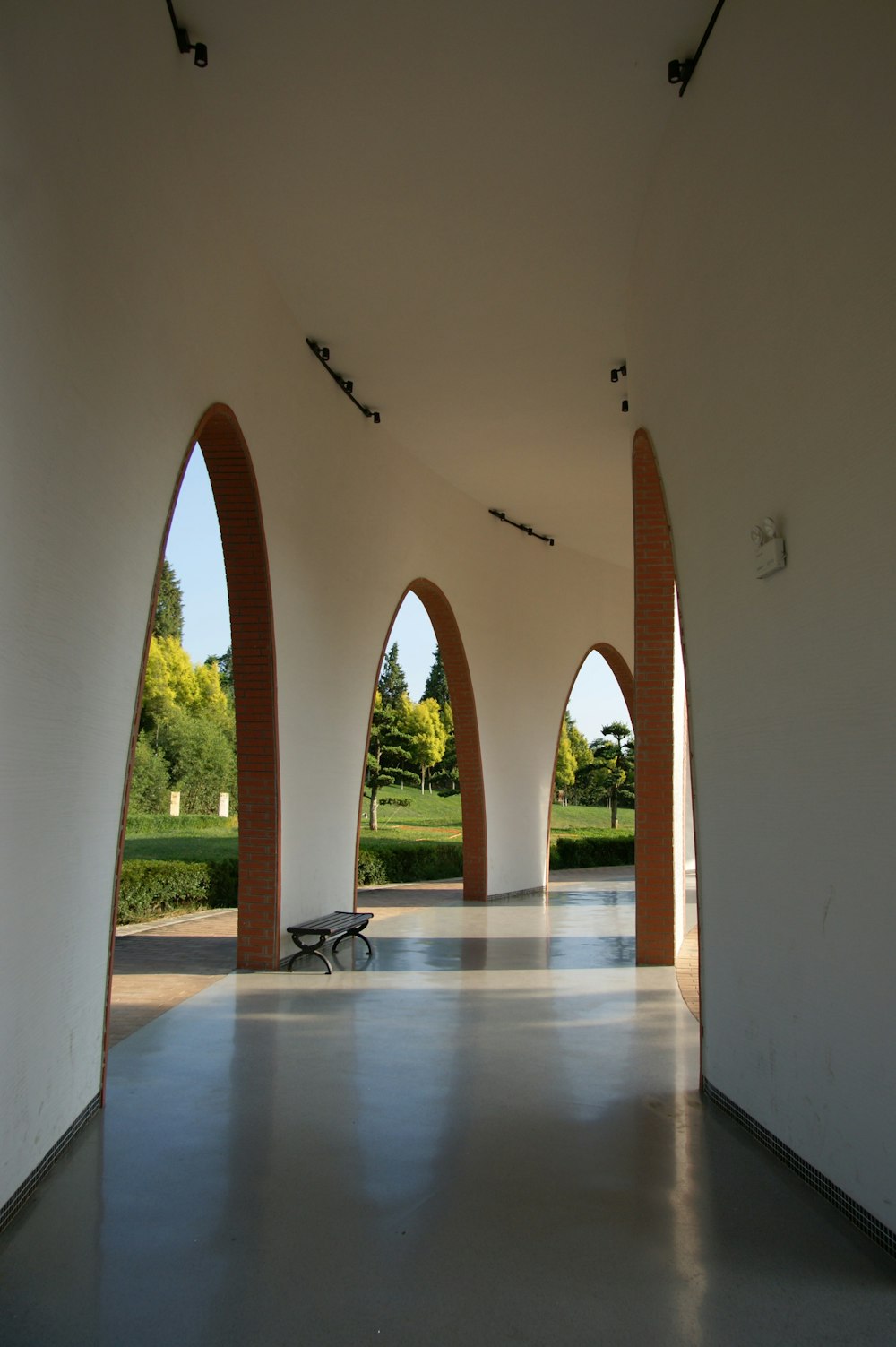 a room with arches and a bench in it