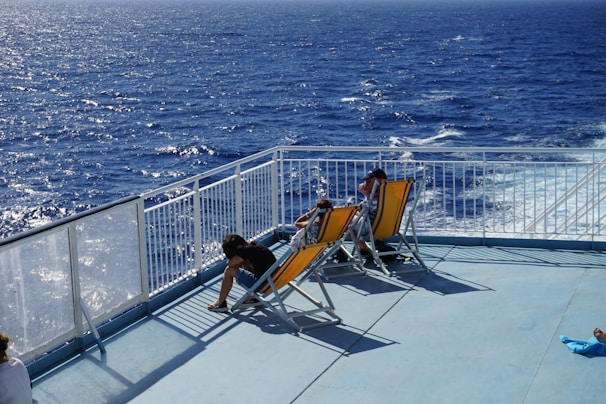 Relaxed passengers lounging on the deck chairs, sipping drinks and soaking up the sun.