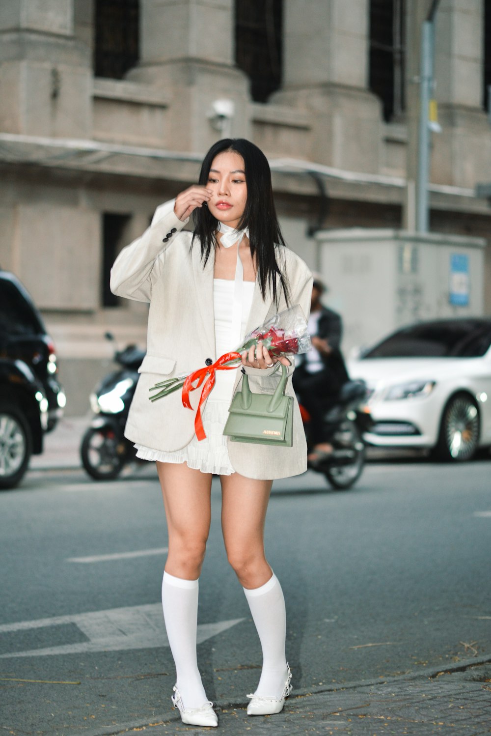 a woman standing on the side of a road