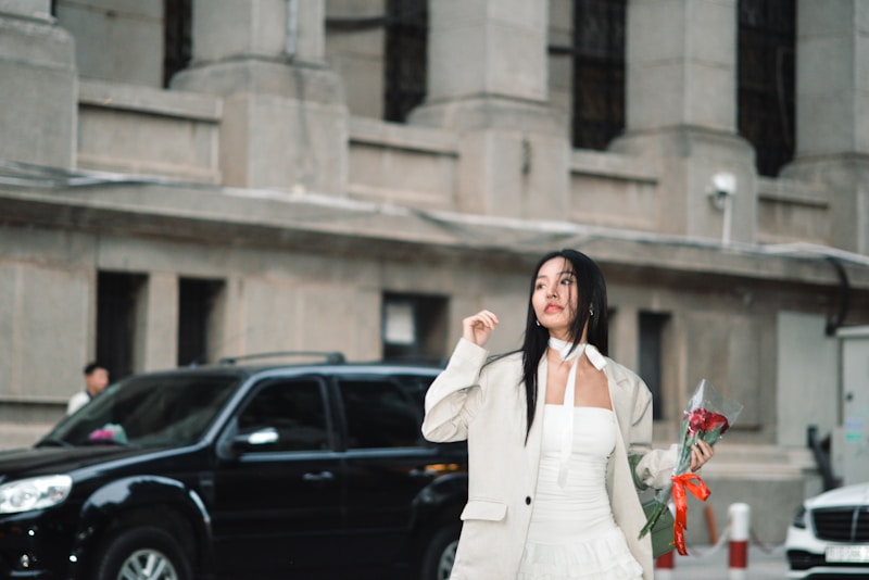 a woman in a white dress is walking down the street