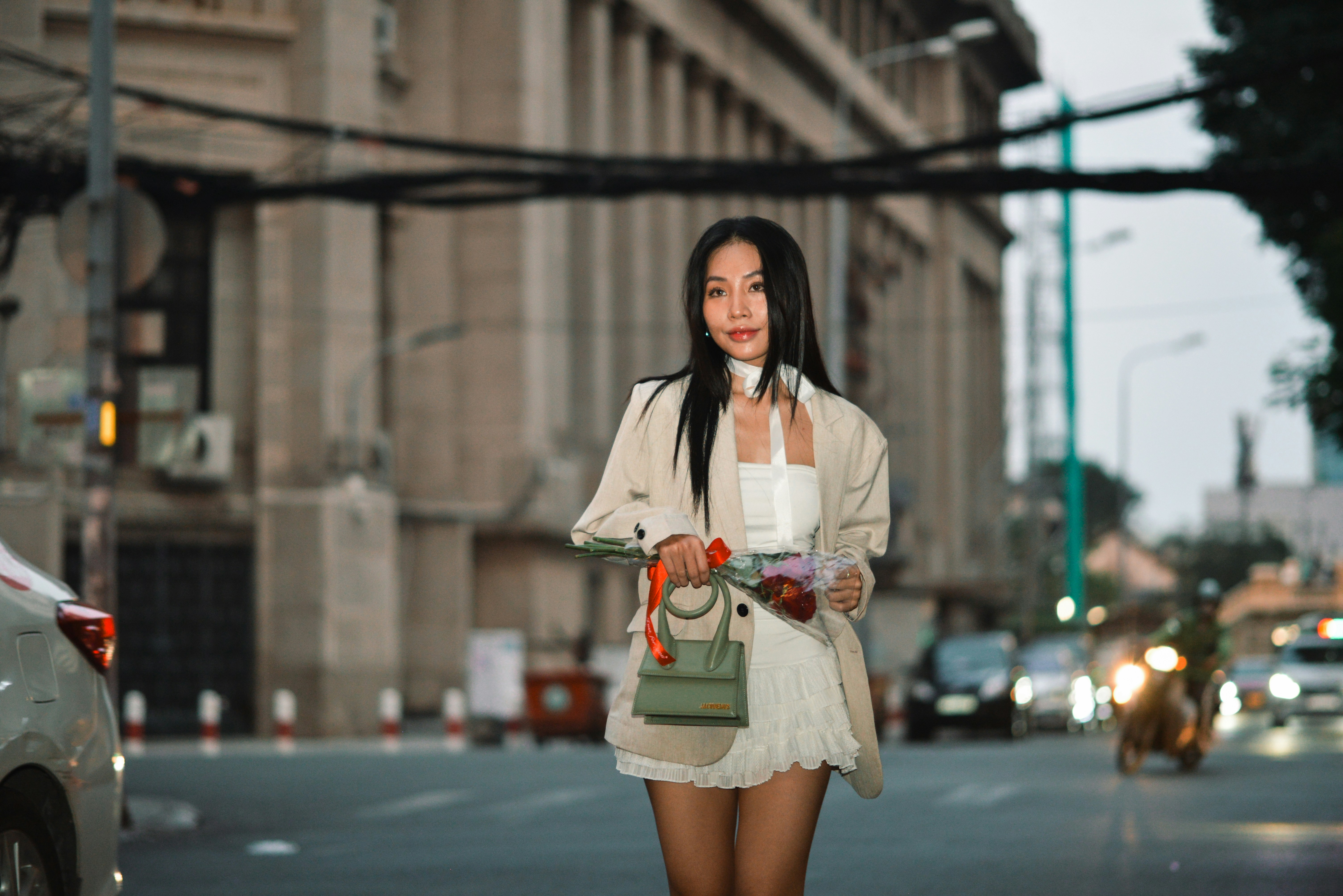 a woman walking down a street holding a purse