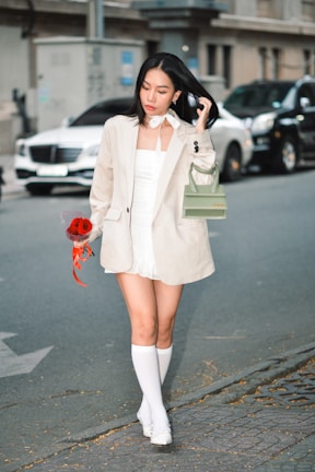 a woman walking down a street holding a purse