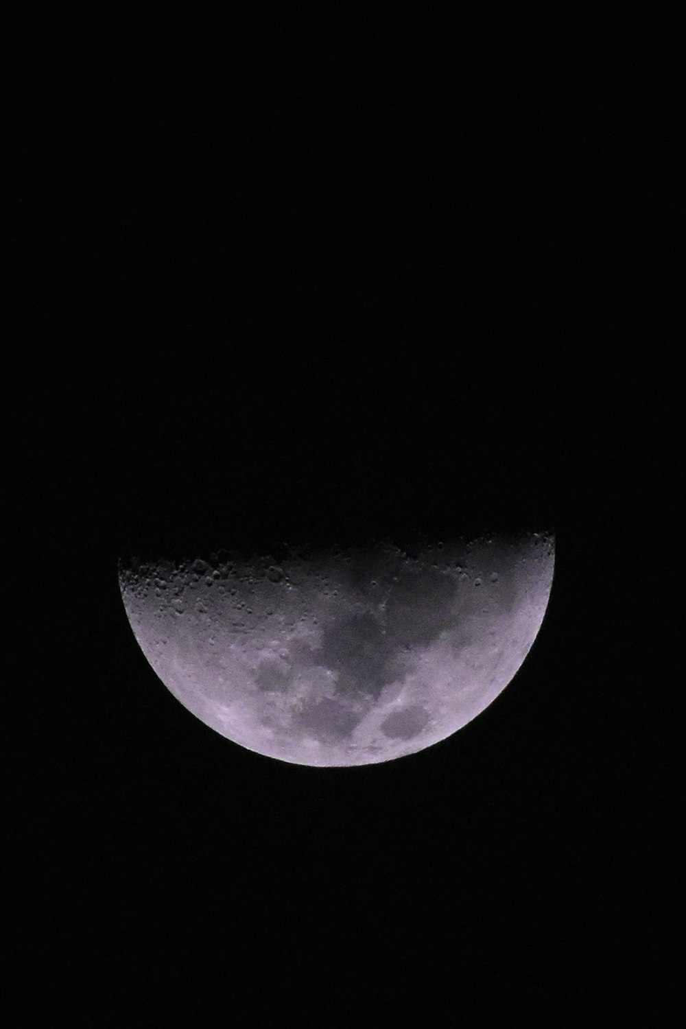 the moon is seen through a dark sky