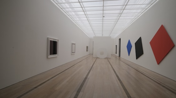 Bright, airy gallery space with white walls showcasing minimalist contemporary artworks.