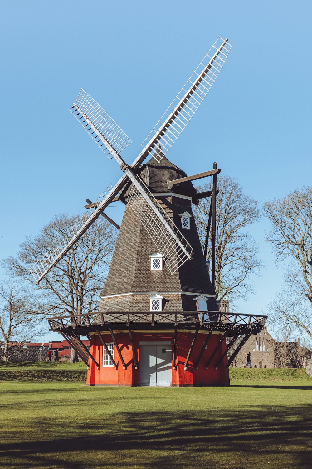 a windmill sitting on top of a lush green field