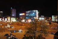 Evening cityscape with Uber vehicles glowing under streetlights, each highlighting different brand ads on their car cards.