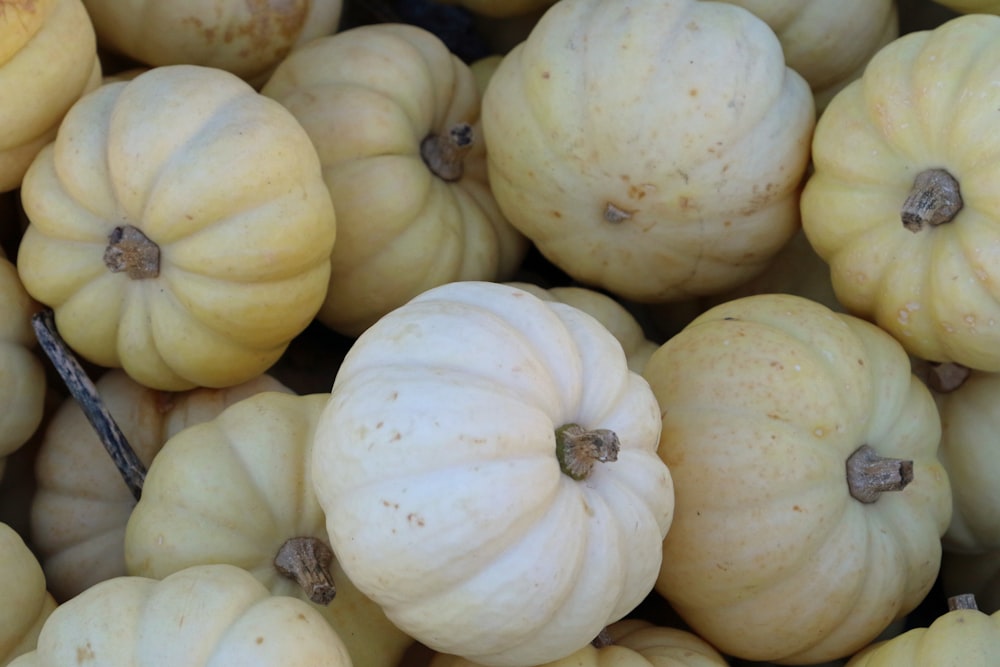 a pile of white pumpkins sitting next to each other