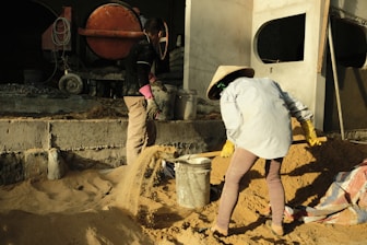 Construction workers operating heavy machinery on a building site at Thanh Nam company