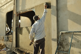 a man standing next to a building with a hammer