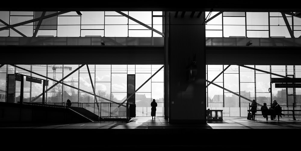 a group of people standing in front of large windows