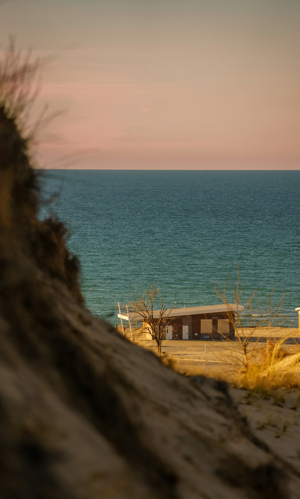 a bench sitting on top of a sandy beach next to the ocean