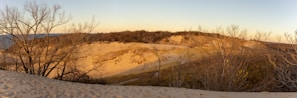 Golden Sahara dunes glowing under a warm sunset sky