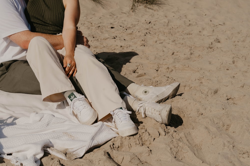 a man and a woman sitting on the sand