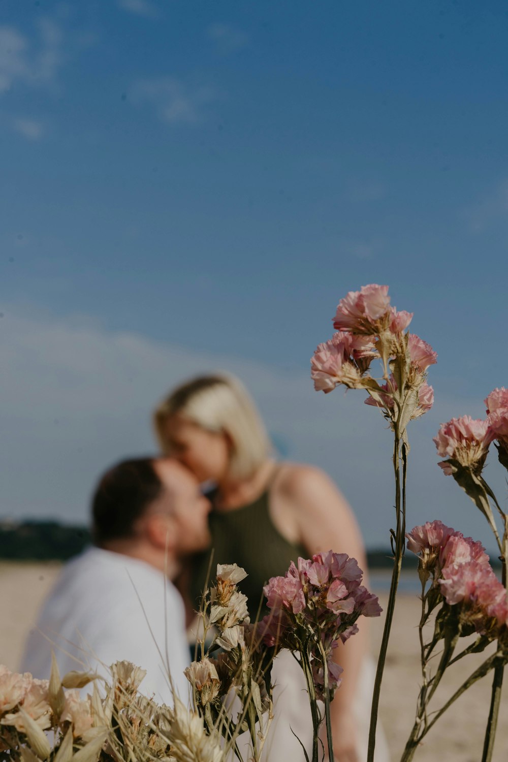 a man and a woman kissing on the beach