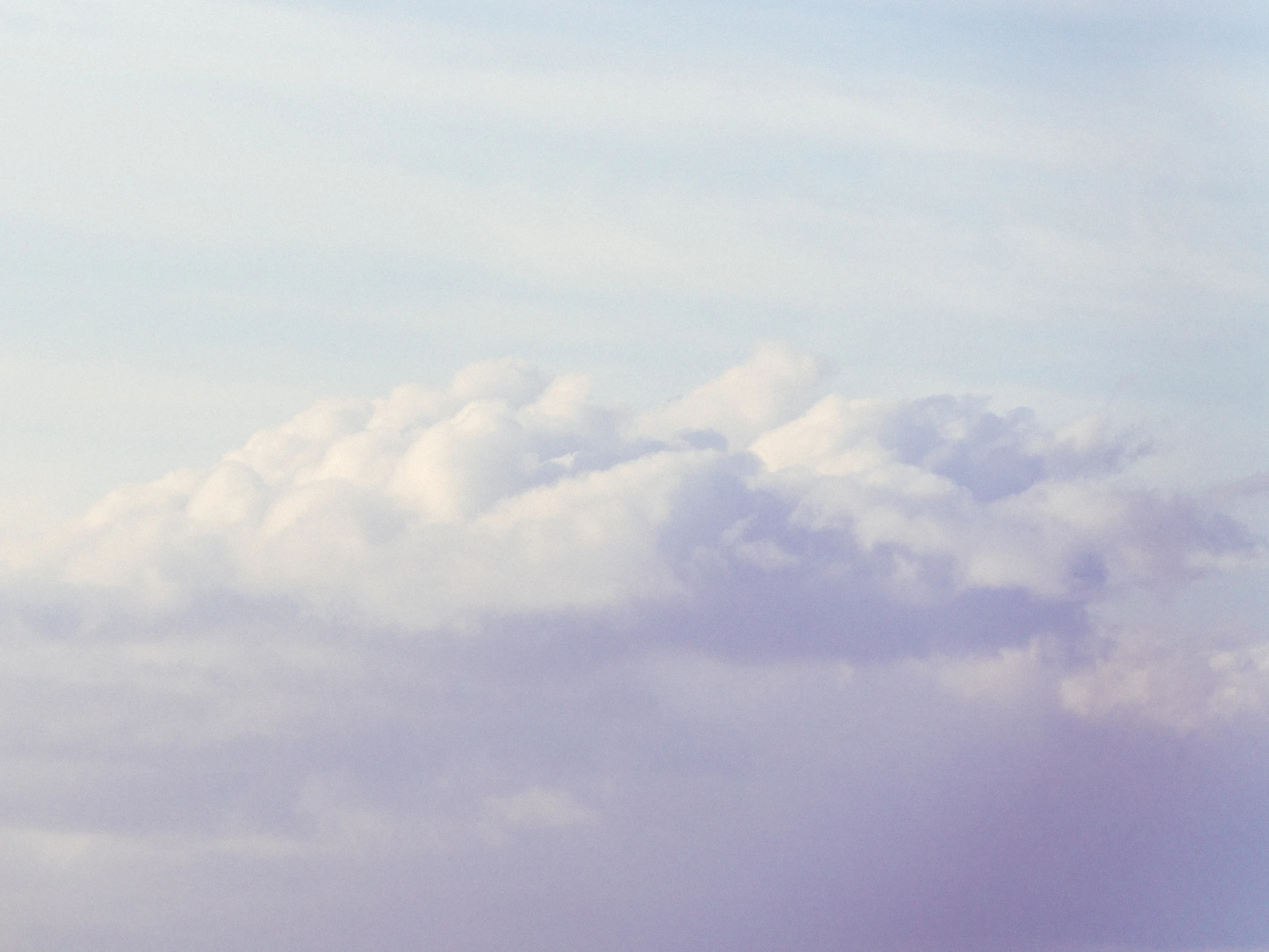 a plane flying in the sky with a lot of clouds in the background