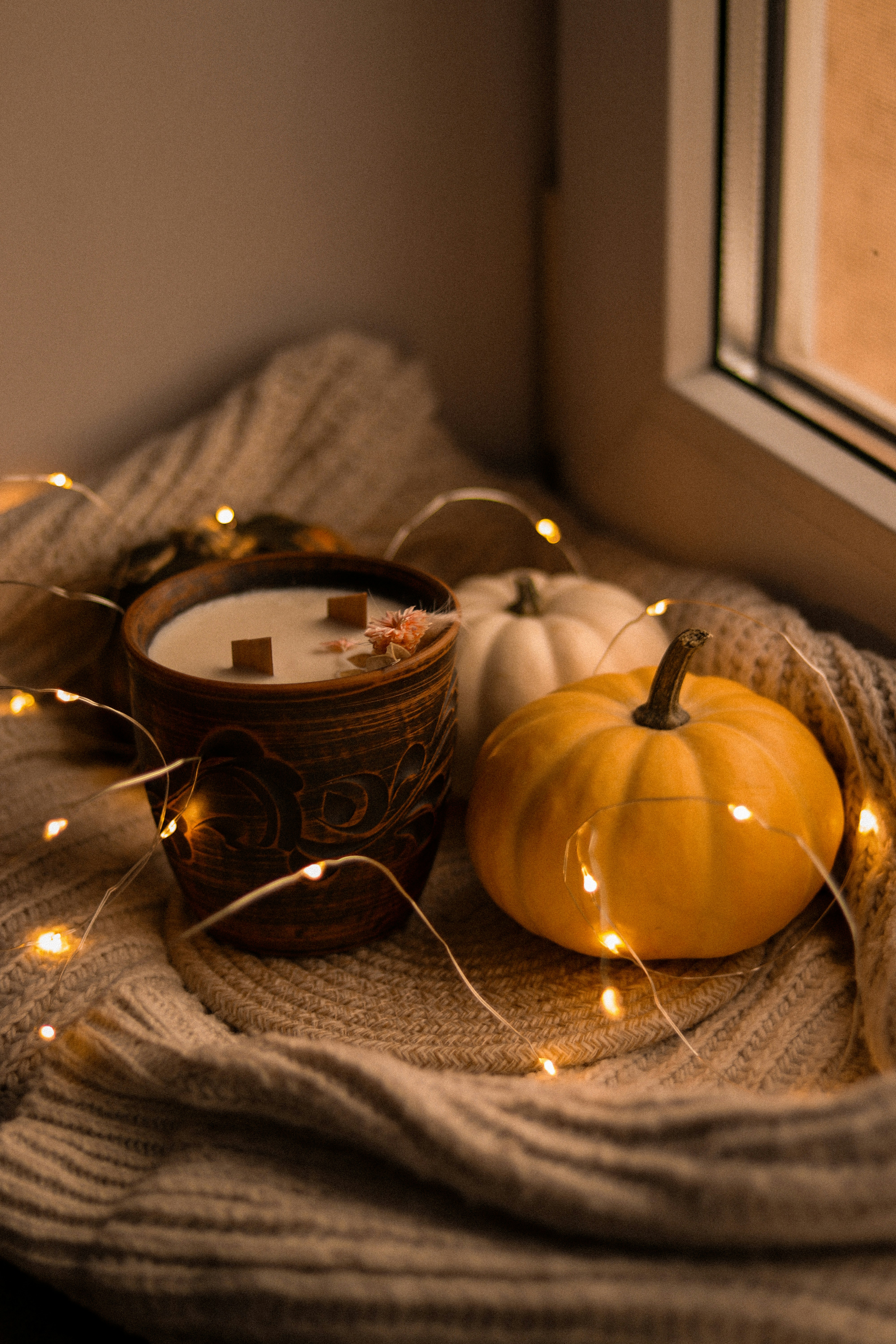 a candle and some pumpkins on a blanket