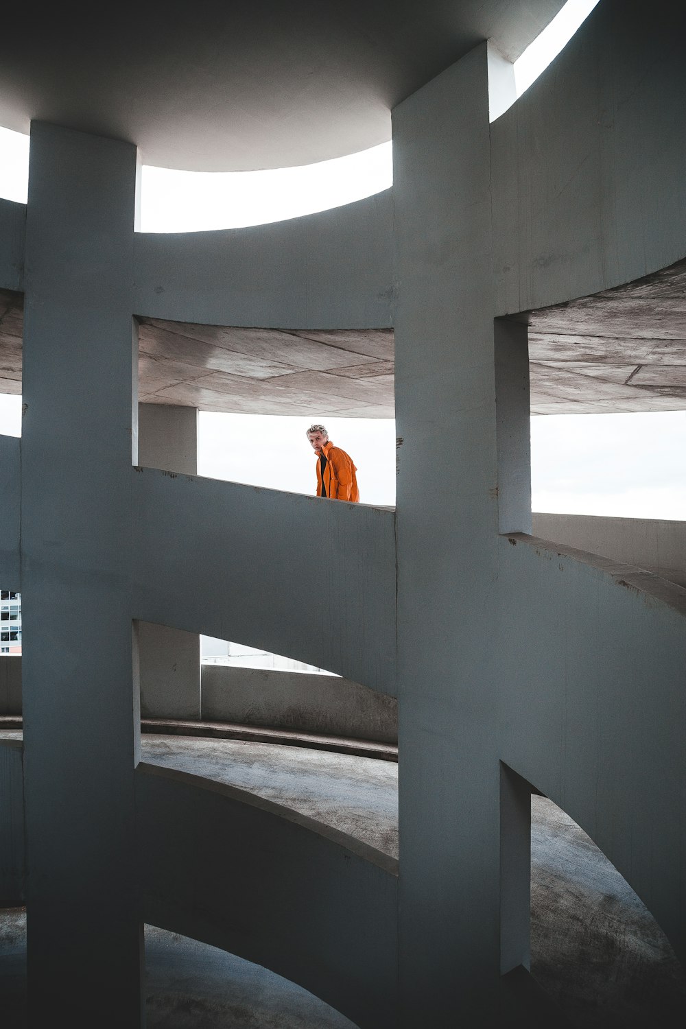 a man in an orange jacket standing in a circular structure
