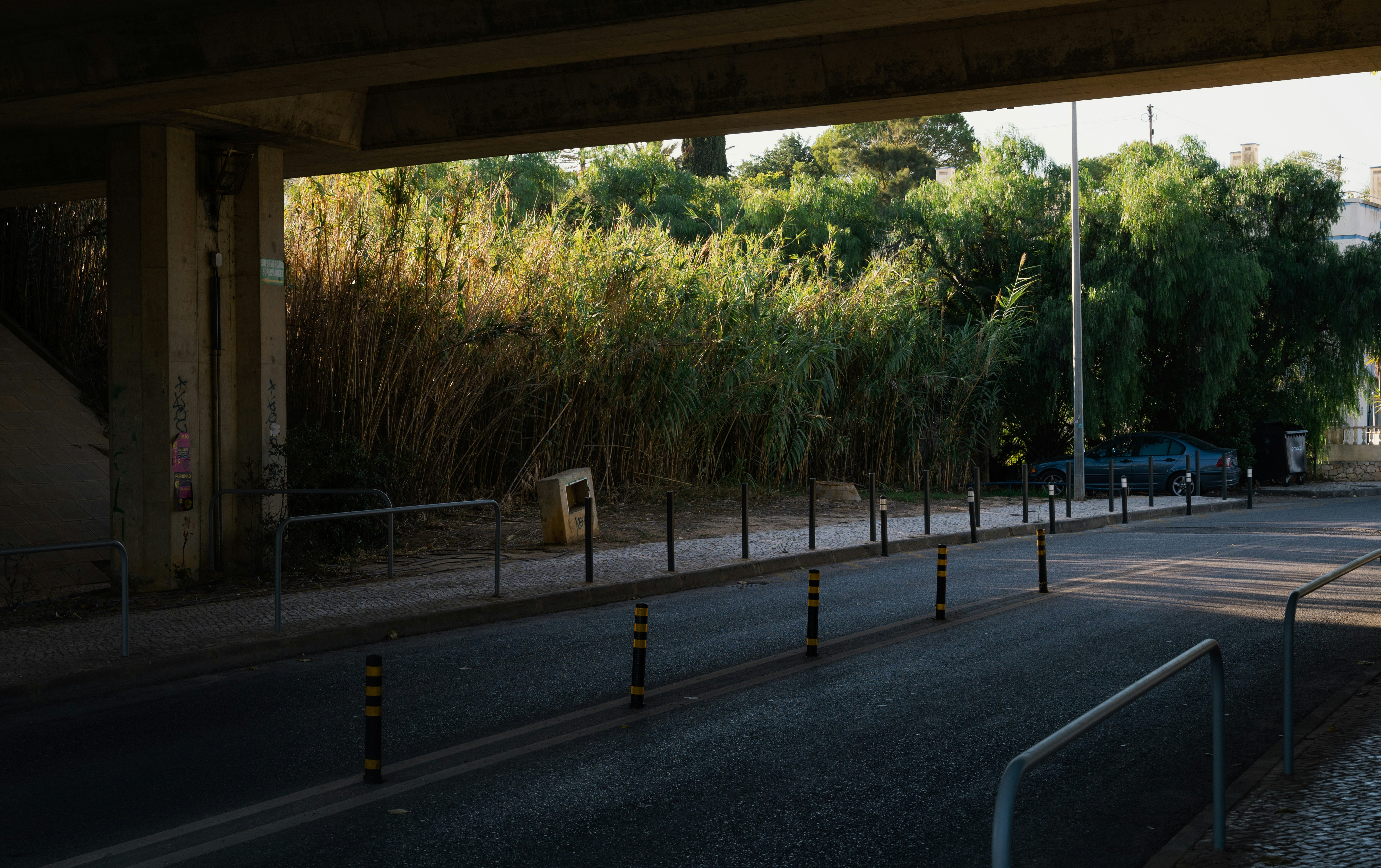 an empty street with a blue truck parked on the side of the road, 