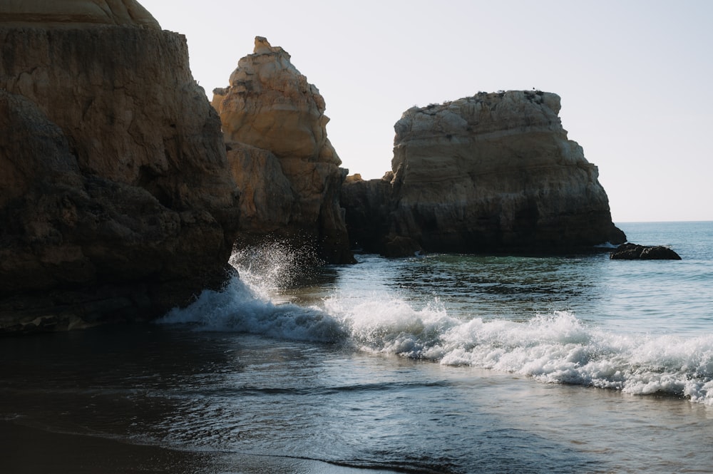 a beach with waves coming in and out of the rocks