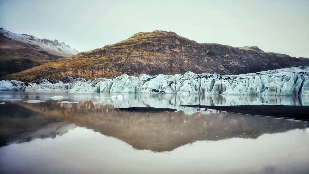 a large glacier with mountains in the background