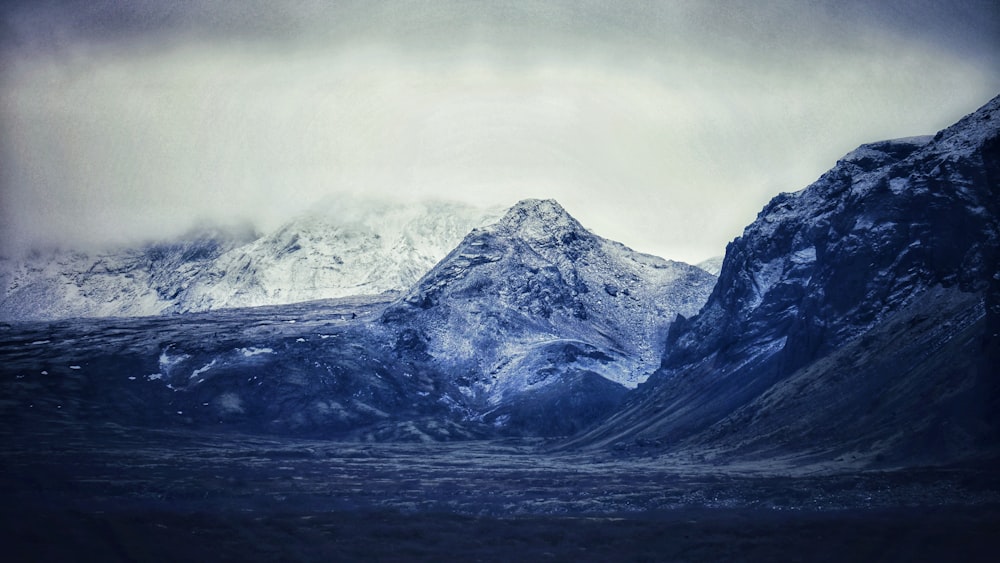 a snow covered mountain with a cloudy sky