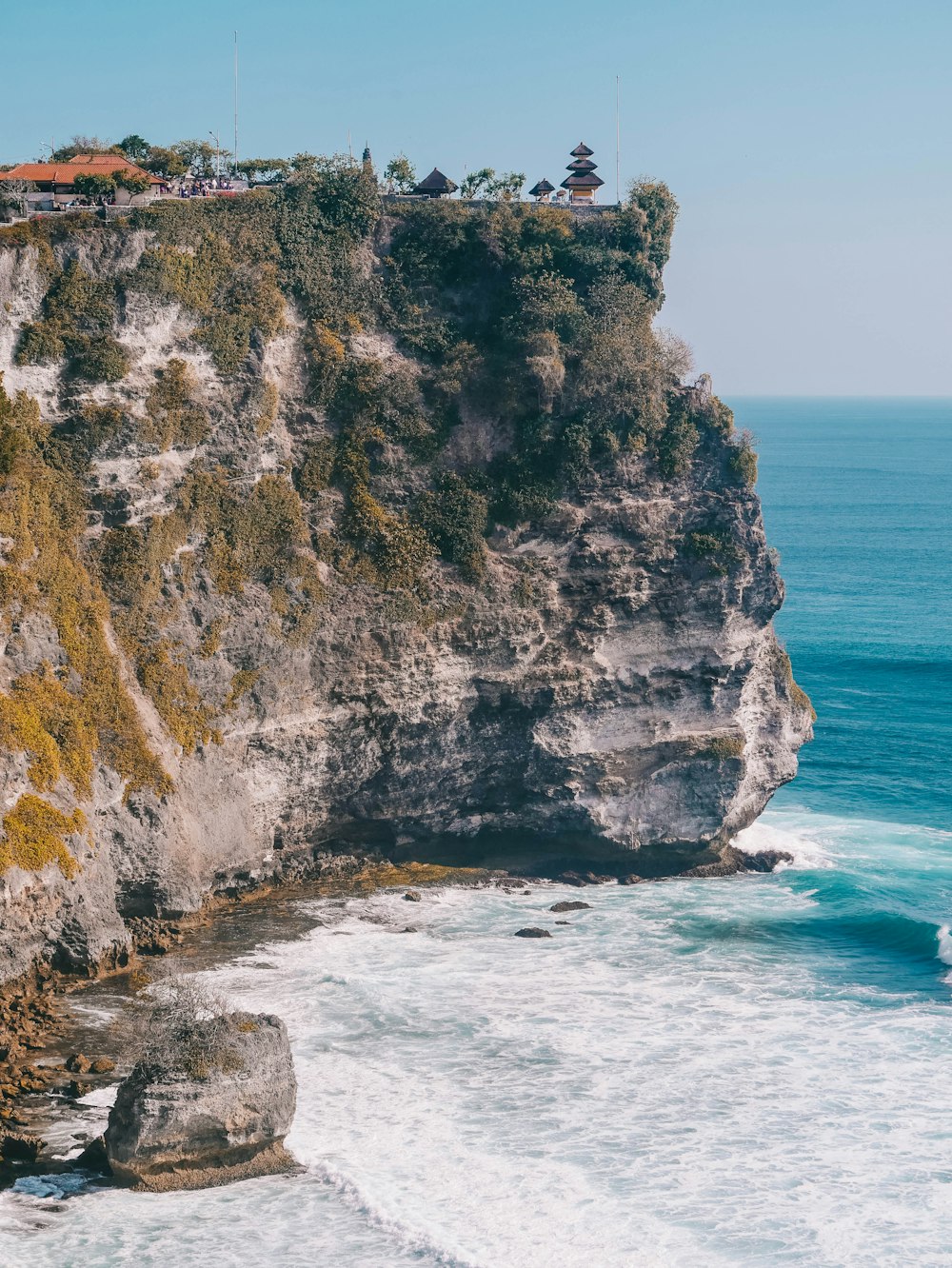 a rocky cliff with a body of water in the foreground