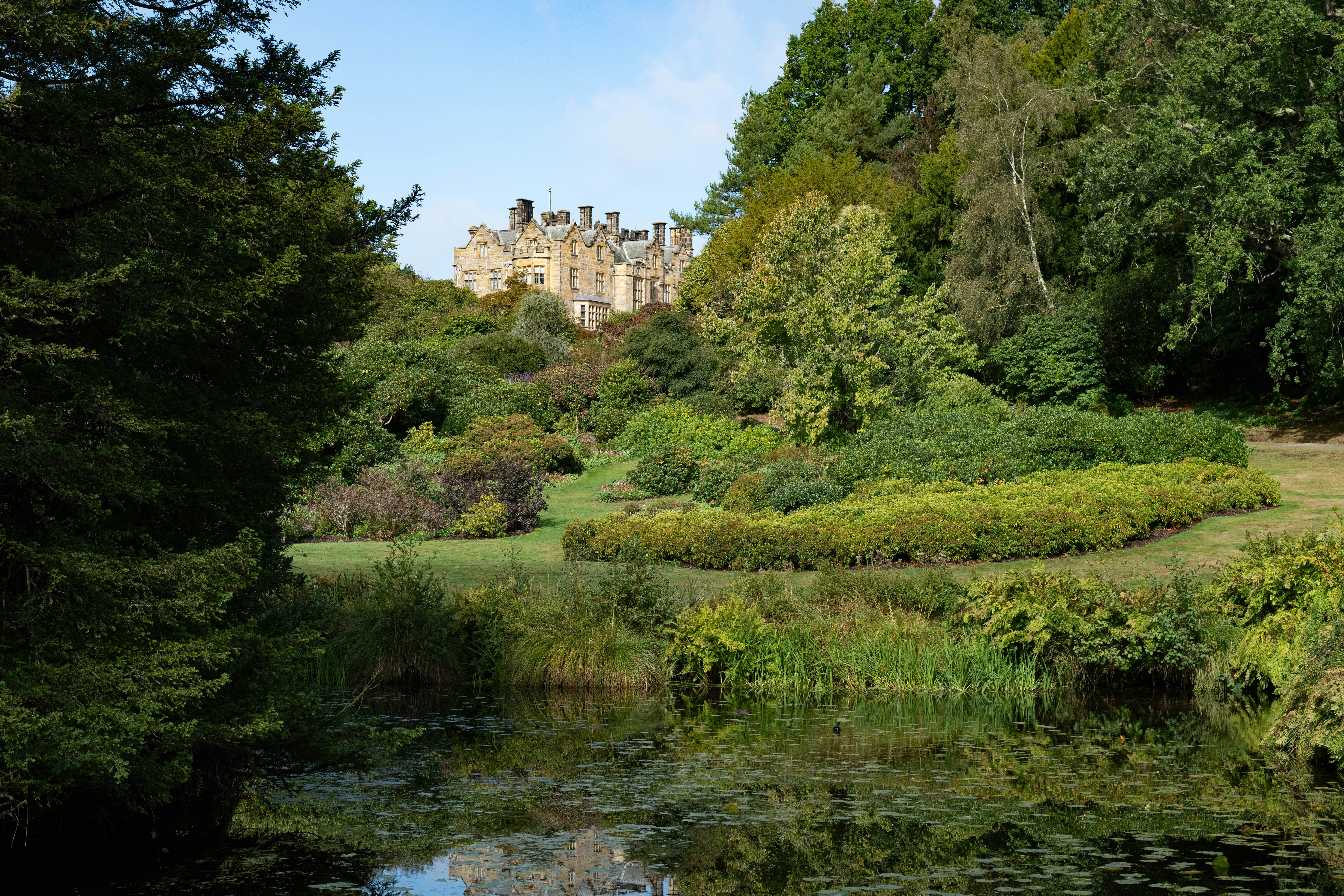 a large building sitting on top of a lush green hillside