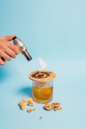 Close-up of artisan hands carefully tending to glowing embers in a traditional mezcal distillation process.