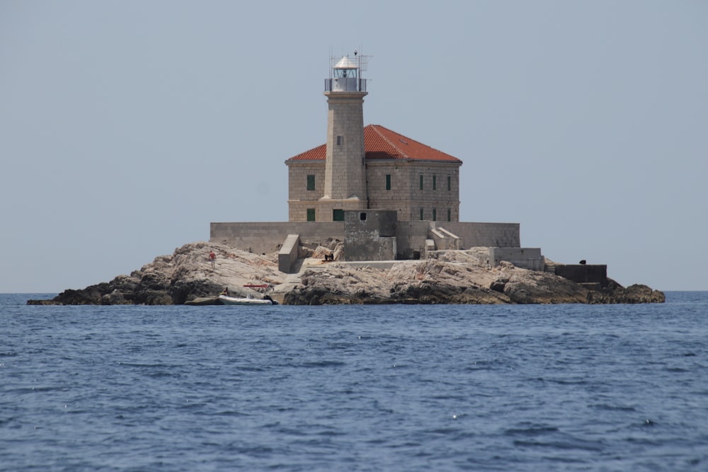 a light house on a small island in the middle of the ocean