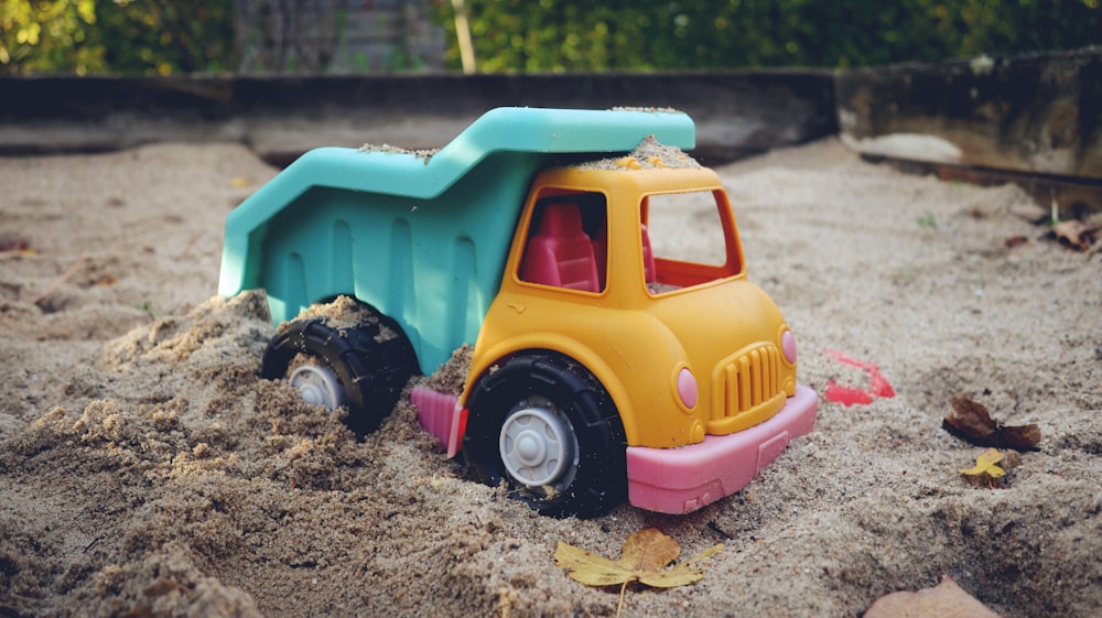 a toy dump truck is in the sand