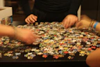 A close-up of puzzle glue and sorting trays arranged neatly on a wooden table.