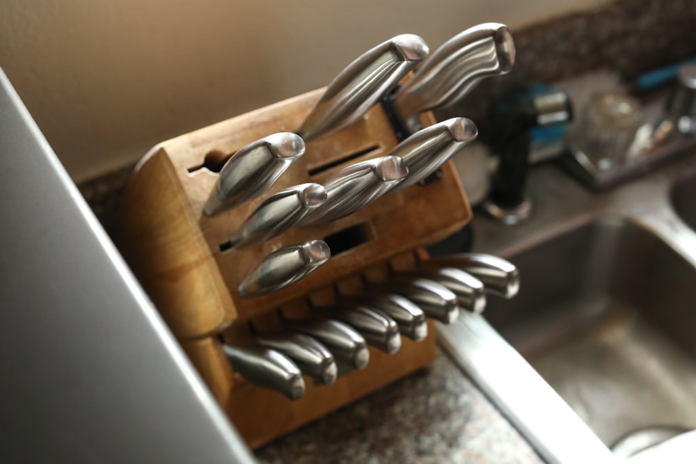 a bunch of knives are hanging on a rack