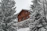 A cozy wooden chalet surrounded by lush green trees in the Mantiqueira mountains.