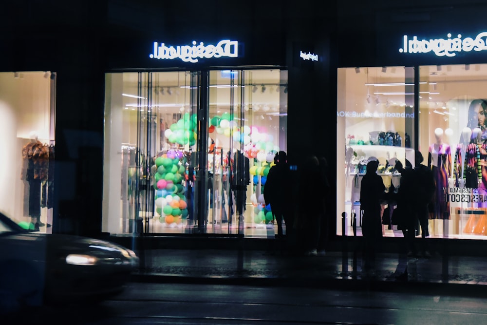 a group of people standing outside of a clothing store