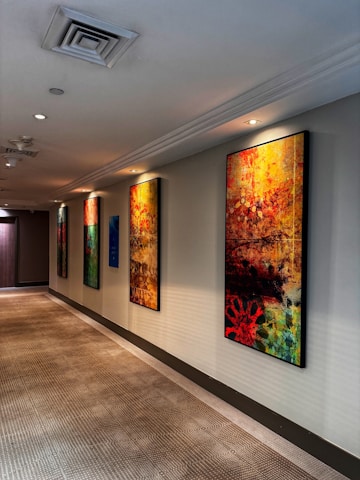 Close-up of a painter applying vibrant floor paint in a residential hallway.