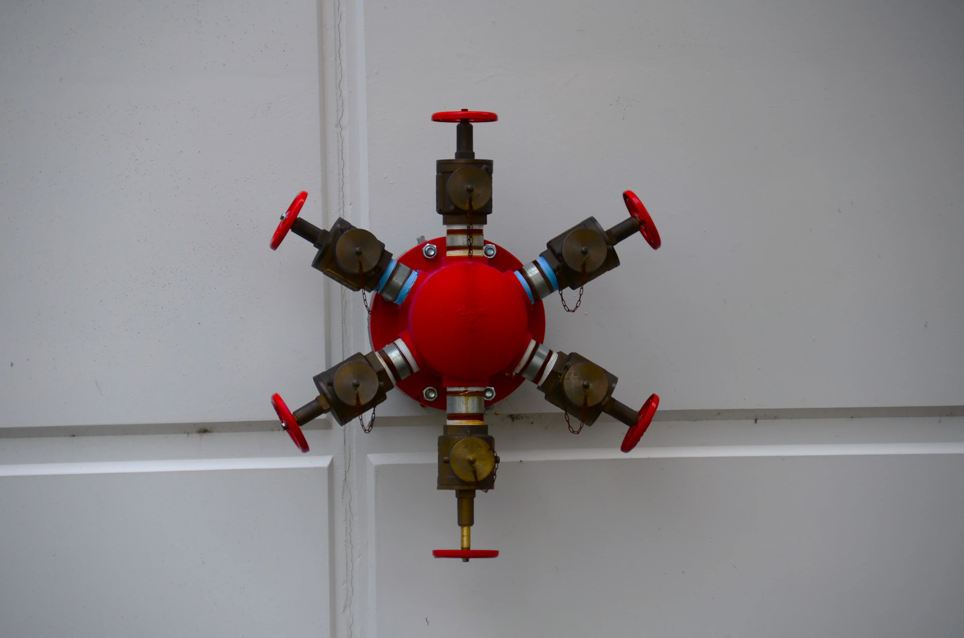 a red and gold clock on a white wall