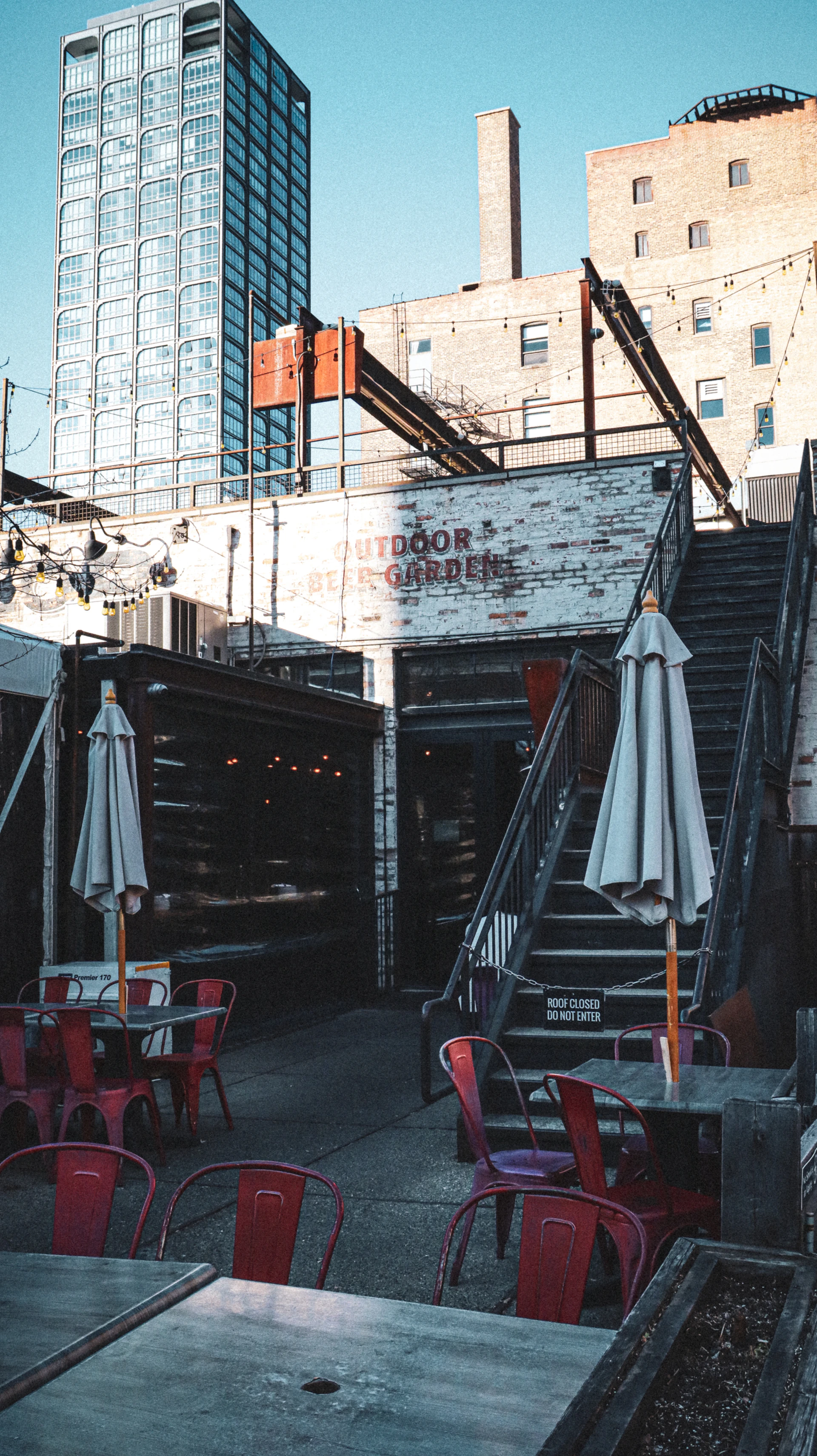 tables and chairs outside of a restaurant with a building in the background