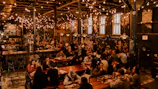 A panoramic shot of a trendy food restaurant’s vibrant dining area filled with happy patrons.