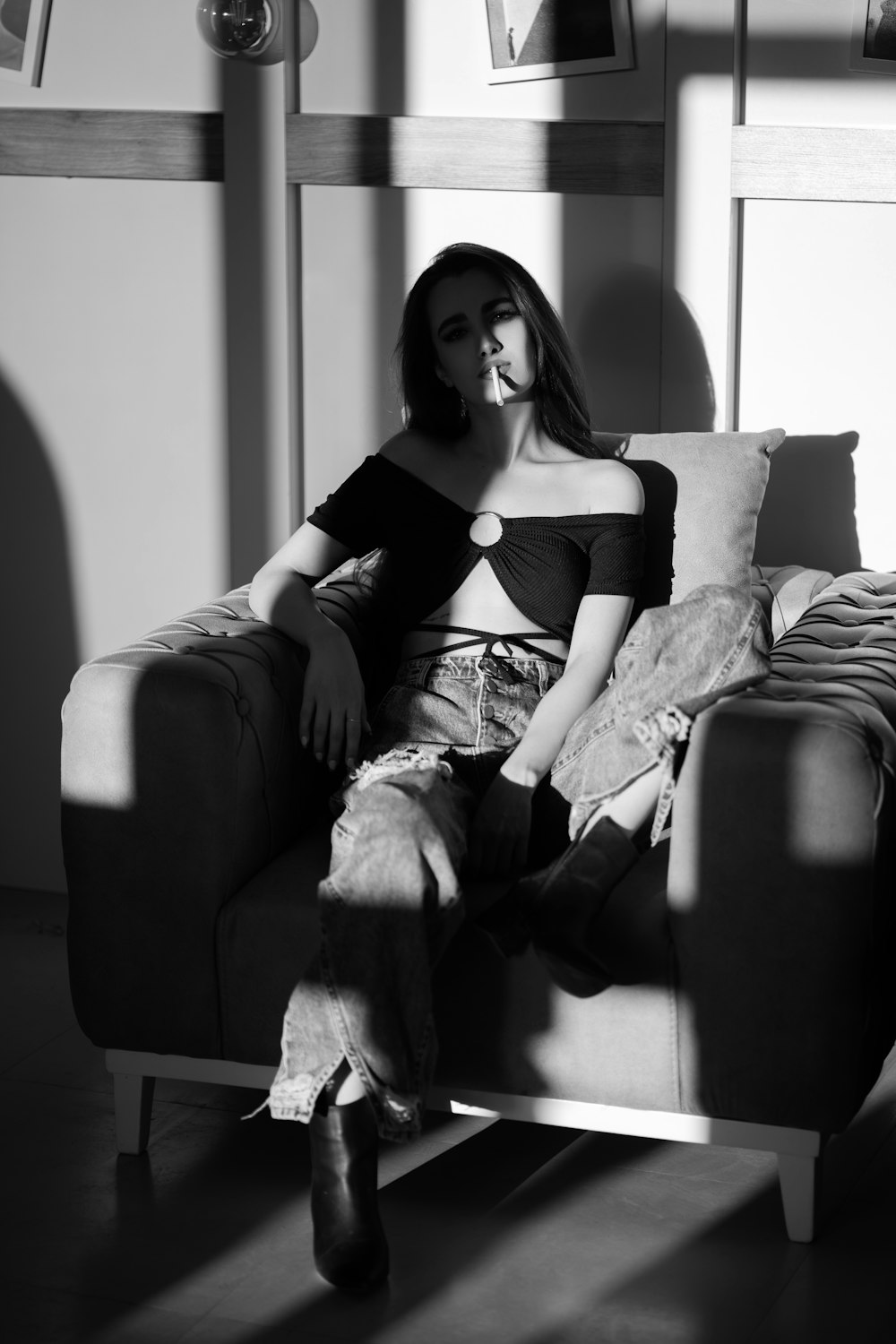 a black and white photo of a woman sitting on a couch