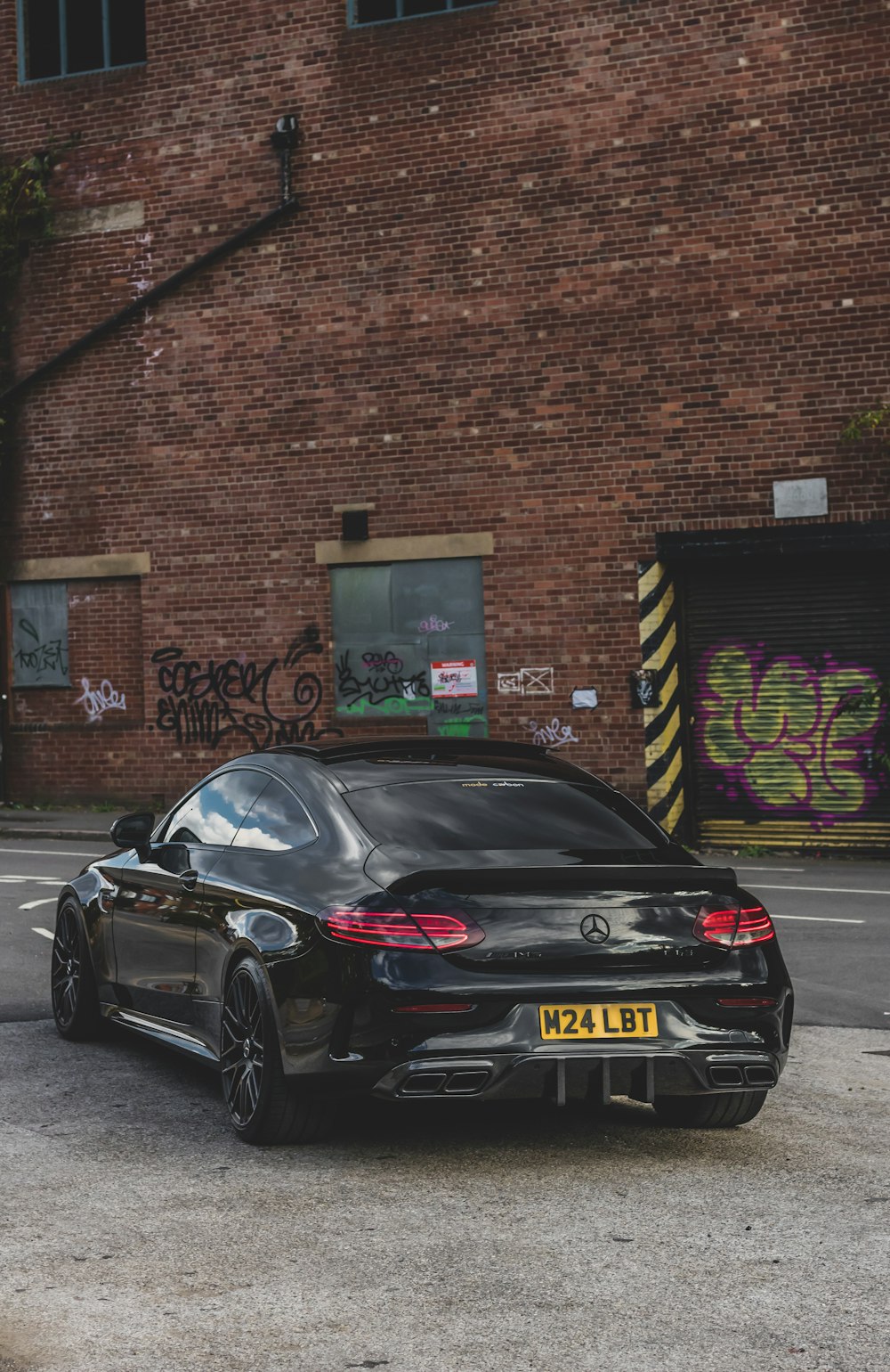 a black sports car parked in front of a brick building