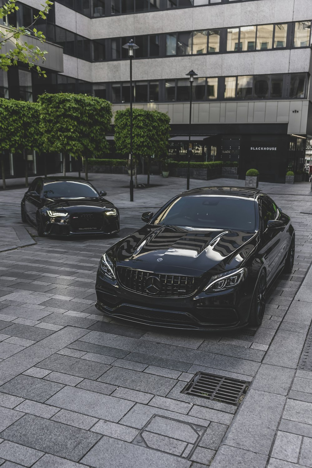a couple of black cars parked next to each other
