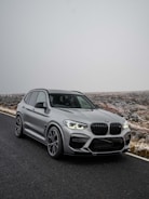 A bright green hybrid SUV parked in a snowy Finnish forest.