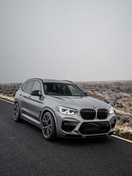 A bright green hybrid SUV parked in a snowy Finnish forest.