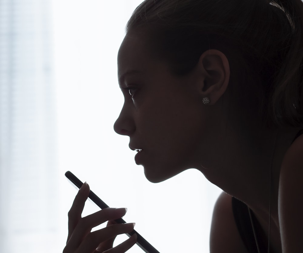 a woman is holding a pen and looking at something