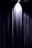A dark curtain is partially illuminated by a single overhead spotlight, creating a dramatic contrast between the fabric and the surrounding dimness.