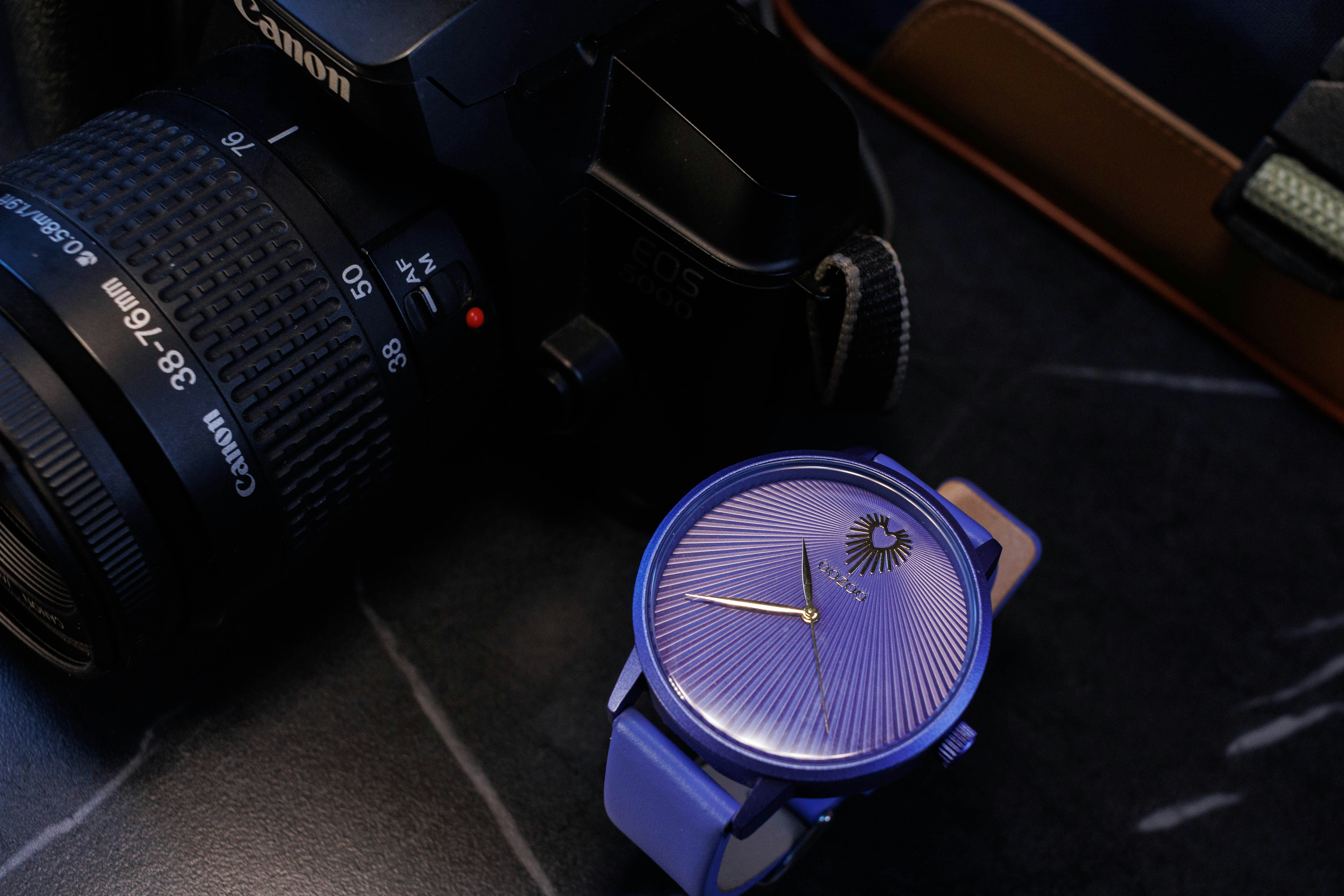 a camera and a watch on a table